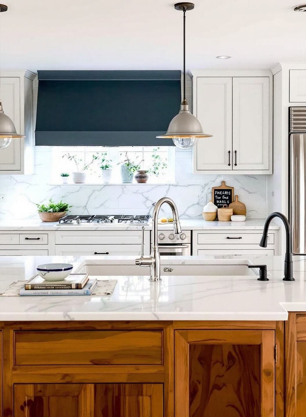 Stylish kitchen with waterfall island, pendant lights, marble backsplash, quartz countertops highlighted by morning light, decor groups of three, and under-cabinet lighting.