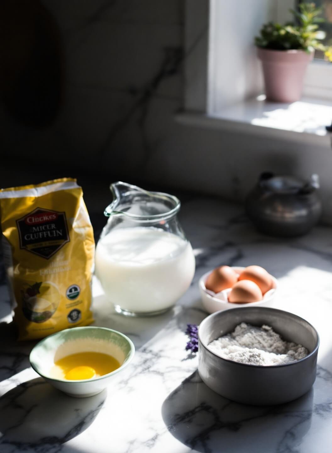 Ingredients for making crepes including flour, eggs, and milk, prepared on a sunlit marble kitchen counter in soft morning light.