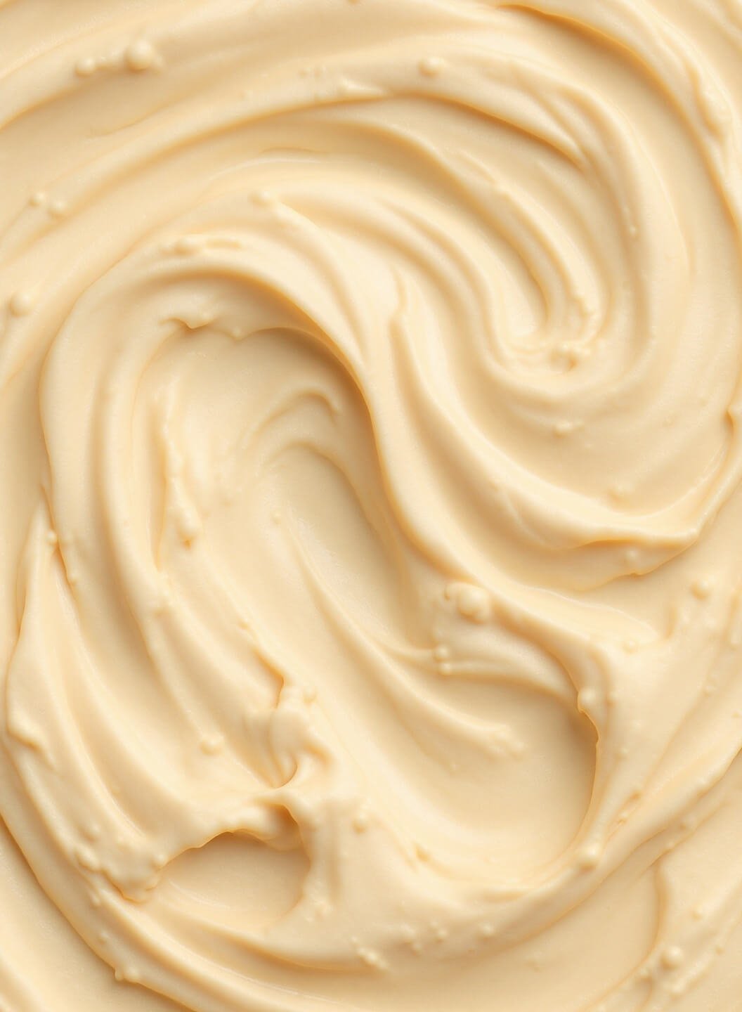 Close-up texture of silky smooth hummus in a vortex pattern